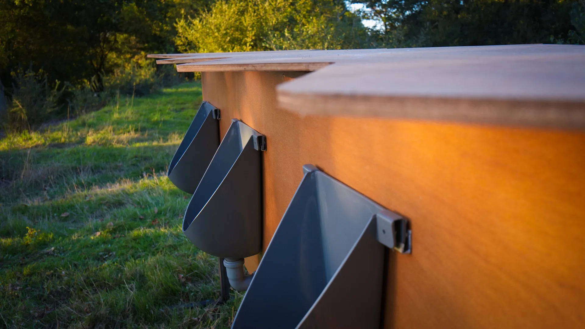 Urinoirs autonomes en bois installés sur un site événementiel extérieur